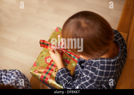 Kleiner Junge Auspacken ein Weihnachtsgeschenk Stockfoto