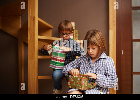 Zwei Geschwister Weihnachtsgeschenke auspacken Stockfoto