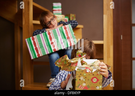 Zwei Geschwister Weihnachtsgeschenke auspacken Stockfoto