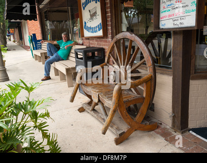 Wagon Wheel Stuhl vor Conestoga Restaurant entlang der historischen Main Street im Alachua Florida. Stockfoto