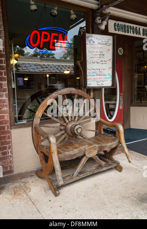 Wagon Wheel Stuhl vor Conestoga Restaurant entlang der historischen Main Street im Alachua Florida. Stockfoto