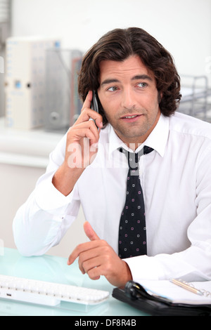 Männlicher Büroangestellter saß am Schreibtisch Stockfoto