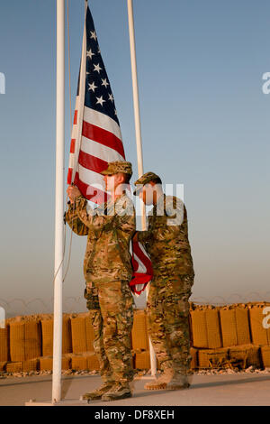 Tarin Kot, Afghanistan. 29. September 2013. Vereinigte Staaten Armee Schutzzertifikate. Michael Arsenault und Jesus Arias senken die Fahnen der Gedenkstätte Camp Holland während der abschließenden Zeit 29. September 2013 in Tarin Kot, Afghanistan. Als amerikanische Truppen weiterhin Truppen in Afghanistan zu ziehen wird das Camp an afghanische Kräfte übergeben. © Planetpix/Alamy Live-Nachrichten Stockfoto