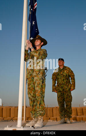 Tarin Kot, Afghanistan. 29. September 2013. Royal Australian Air Force Warrant Officer Jennine Reichtum und Sgt. Chris Cambell senken die australische Flagge bei einer niedrigeren Flagge Zeremonie der Gedenkstätte Camp Holland während der abschließenden Zeit 29. September 2013 in Tarin Kot, Afghanistan. Als ISAF weiterhin Truppen in Afghanistan ziehen Sie nach unten, die das Camp an die afghanischen Sicherheitskräfte übergeben wird. © Planetpix/Alamy Live-Nachrichten Stockfoto