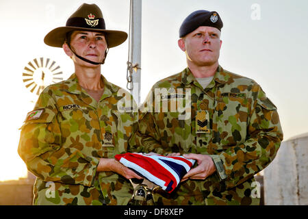 Tarin Kot, Afghanistan. 29. September 2013. Royal Australian Air Force Warrant Officer Jennine Reichtum und Sgt. Chris Cambell halten die gefalteten australische Flagge nach einem niedrigeren die Fahnen der Gedenkstätte Camp Holland während der abschließenden Zeit 29. September 2013 in Tarin Kot, Afghanistan. Als ISAF weiterhin Truppen in Afghanistan ziehen Sie nach unten, die das Camp an die afghanischen Sicherheitskräfte übergeben wird. © Planetpix/Alamy Live-Nachrichten Stockfoto