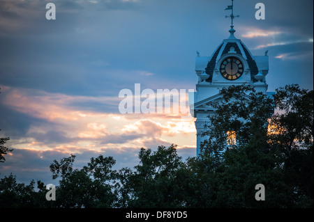 Die Abenddämmerung beginnt am Gwinnett Historic Courthouse in Lawrenceville, Georgia, während die untergehende Sonne die Turmuhr beleuchtet. (USA) Stockfoto