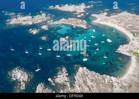 LUFTAUFNAHME. Yachten ankerten in der azurblauen Bucht von Cala Lazarina. Lavezzi Island, Bonifacio, Korsika, Frankreich. Stockfoto