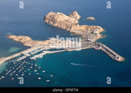 LUFTAUFNAHME. Die Insel Pietra mit ihrem Fährhafen und der Straße, die zur Altstadt von L'Île Rousse führt. Haute-Corse, Korsika, Frankreich. Stockfoto