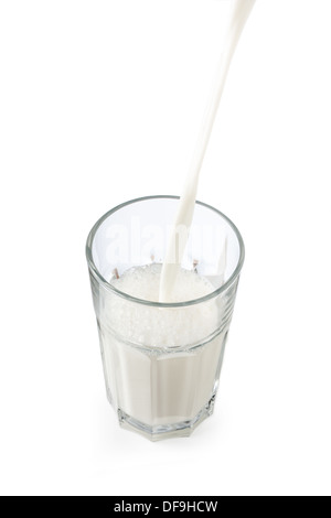 Gießen Milch in ein Glas isoliert auf weiss Stockfoto