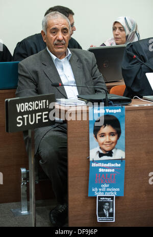Ismael und Ayse Yozgat, Eltern des Opfers Kassel NSU Halit Yozgat, setzen Sie sich vor gemeinsamen Kläger Rechtsanwälte im Gerichtssaal an das Oberlandesgericht in München, 01 Oktober 2013.A Foto von Halit wie ein Kind und eine Nachfrage, die Straße Hollaendische Strasse als Halit Straße umzubenennen oder den verlorenen Sohn zurück hängt vom Tisch. Die Verhandlung des Falles verbunden, die Morde von deutschen extremen Rechten Terror-Zelle nationalen sozialistischen Untergrund (NSU) weiter in München. Foto: ANDREAS GEBERT Stockfoto