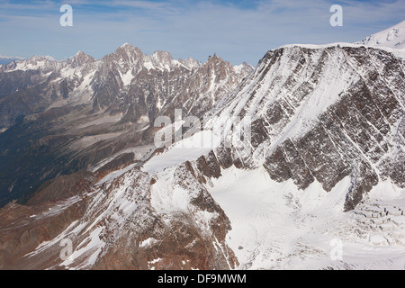 LUFTAUFNAHME. Aiguille du Goûter (rechts) mit Aiguille Verte in der Ferne. Chamonix Mont-Blanc, Haute-Savoie, Auvergne-Rhône-Alpes, Frankreich. Stockfoto