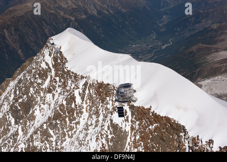 LUFTAUFNAHME. Aiguille du Goûter (Höhe: 3863m) mit der neuen futuristischen Berghütte. Chamonix (Höhe: 1035m) in der Ferne. Frankreich. Stockfoto