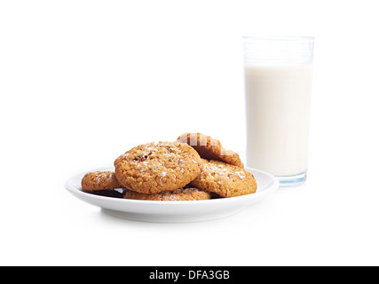 Ein Haufen von gemischten Cookies auf einem weißen Teller und Hintergrund mit einem Glas Milch. Stockfoto