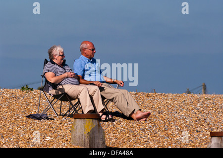 Blick nach vorne auf ein älteres Ehepaar sitzt auf Strandkörbe Stockfoto