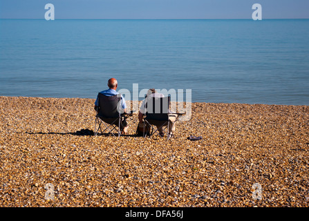 Rückansicht des ein älteres Ehepaar sitzt auf Strandkörbe Blick aus Meer Stockfoto