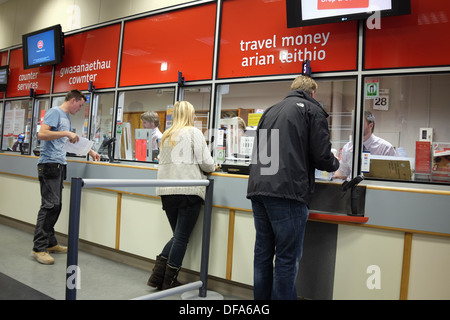 Menschen, die an einem Schalter der Royal Mail Post Office, UK serviert Stockfoto