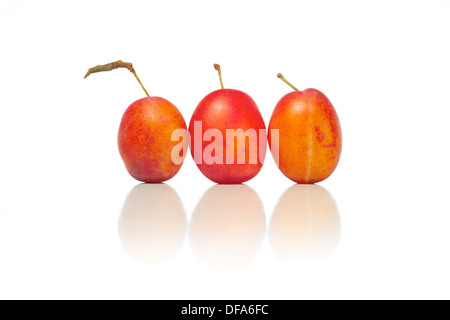 Ganze und halbe Pflaumen auf weißem Hintergrund. Stockfoto