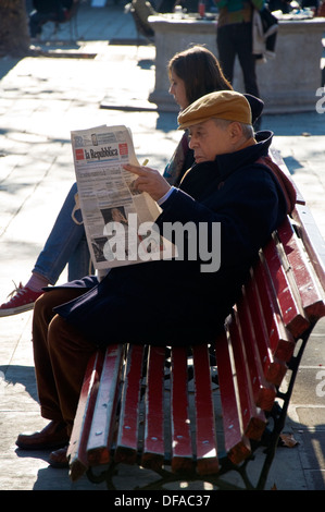 Mann liest Zeitung La Repubblica auf einem Venedig-Platz auf einer Bank sitzend Stockfoto