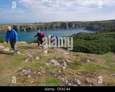 Insel von Anglesey Küsten Weg Wales Nordgruppe der Wanderer auf diesem legendären Weg über Porth Eilian mit Lynas Point Leuchtturm Stockfoto