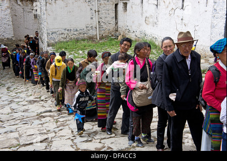 Buddhistische Pilger anstellen an geben das Tashilhunpo Kloster in Shigatse, Tibet Stockfoto