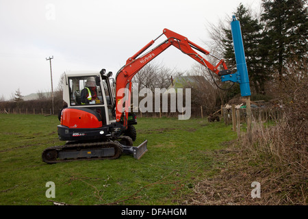 Ein Kubota mit einem Post Stanzen attachment UK Stockfoto