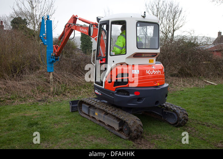 Ein Kubota mit einem Post Stanzen attachment UK Stockfoto