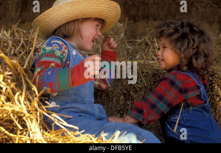 zwei Ranch Kinder in einer Scheune spielen Stockfoto