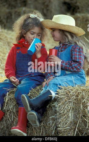 zwei Ranch Kinder in einer Scheune spielen Stockfoto