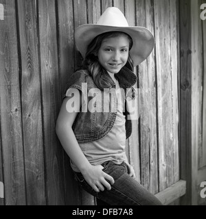 Kinder Mädchen als Kind Cowboy Mädchen Cowgirl posiert auf hölzernen Zaun weit West Stil Stockfoto