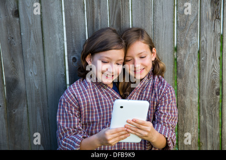 Zwillingsmädchen Phantasie verkleidet vorgibt, siamesische mit Papa t-Shirt mit TabletPC spielen werden Stockfoto