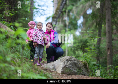 Mutter mit zwei kleinen Zwillingen Töchtern im immergrünen Wald wandern Stockfoto