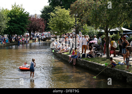 UK, Bourton-auf-dem-Wasser: Menschen spielen in der River Windrush. Bourton ist ein beliebtes Touristenziel in den Cotswolds. Stockfoto