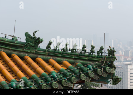 Yuejiang Lou, Nanjing, China. Detail eines Dachs auf der Yuejiang Lou mit Blick auf die Skyline einer nebligen Nanjing. Stockfoto