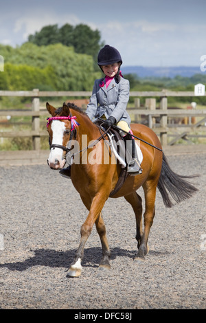 Ein Konkurrent mit ihrem Pferd an einem Outdoor-Reitwettbewerb Stockfoto