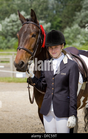 Ein Konkurrent mit ihrem Pferd an einem Outdoor-Reitwettbewerb Stockfoto