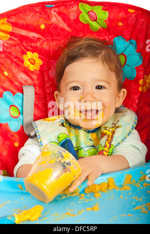 Glückliches Baby im Stuhl sitzen und Essen Gemüse-Püree Stockfoto