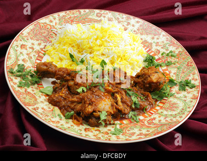 Selbst gemachter Butter Chicken Masala mit gelben und weißen Reis, garniert mit gehackten Korianderblätter. Stockfoto