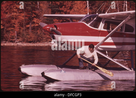Bush-Pilot Ted Anthonsen steht neben seinem 4-Sitzer-Wasserflugzeug, das nahe Old Forge vertäut ist. Das Foto zeigt die Anfänge der Luftfahrt- und Wasserflugzeugtechnik, die in abgelegenen Gebieten für Transport und Lieferung von Lieferungen eingesetzt wurde. Stockfoto