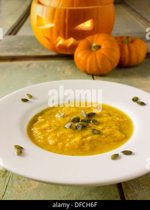 & Speck Kürbis-Suppe mit einem traditionellen Haloween-Kürbis mit einem geschnitzten Gesicht Stockfoto