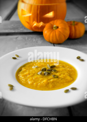 & Speck Kürbis-Suppe mit einem traditionellen Haloween-Kürbis mit einem geschnitzten Gesicht Stockfoto