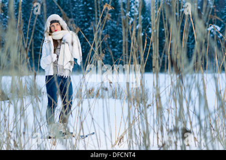 Winter, Frau mit einem Schneeschuhe posiert hinter dem Schilf, Horizont-format Stockfoto