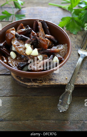 gebratene Pilze mit Knoblauch in einer Keramikschale, Essen Stockfoto