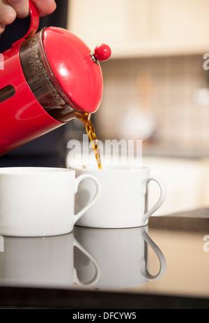 Frisch gemahlener Kaffee gießen in einer roten Getränketablett Stockfoto
