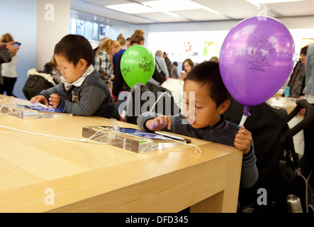 Apple Store Interior; Kinder spielen mit iPads im Apple Store, Norwich, Norfolk UK Stockfoto