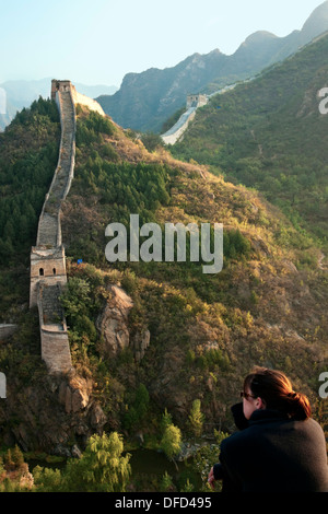 Tourist sitzt mit Blick auf die chinesische Mauer bei Huanghua Cheng (gelbe Blüte), Xishulyu, Jiuduhe Zhen, Huairou, China Stockfoto