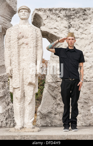 Ungarische Mann grüßen Arbeitnehmers Denkmal während des Besuchs Memento Statue Park in Budapest, Ungarn Stockfoto