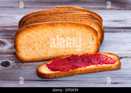 Schmerz-Kühlergrill - Französisch geröstetes Brot mit Marmelade auf einem Holztisch Stockfoto