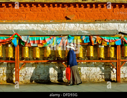 Eine buddhistische Dame dreht Gebetsmühlen außerhalb der Potala-Palast in Lhasa, Tibet. Stockfoto
