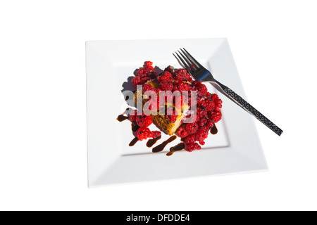 Kaffeekuchen mit frischen Himbeeren und Schokoladenregen auf einem weißen Teller mit Gabel Stockfoto
