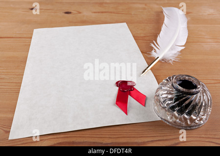 Ein leeres Blatt Pergamentpapier mit Siegel aus rotem Wachs, plus Feder Feder und Glas Tinte gut auf dem Schreibtisch Stockfoto